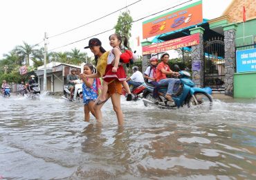 Triều cường Sài Gòn dâng cao, học sinh lội nước theo cha mẹ về nhà